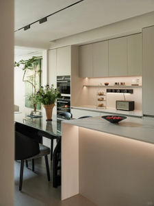 Cozinha em plano aberto de estilo moderno - &aacute;rea de jantar com arm&aacute;rios brancos espa&ccedil;osos e arm&aacute;rios coloridos